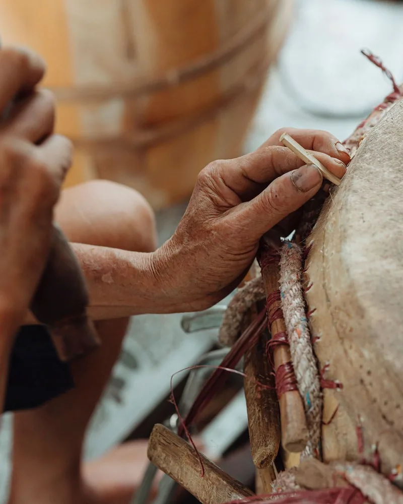 Detalle de una membrana natural sujeta al borde de un tambor mediante cordón y aro de madera
